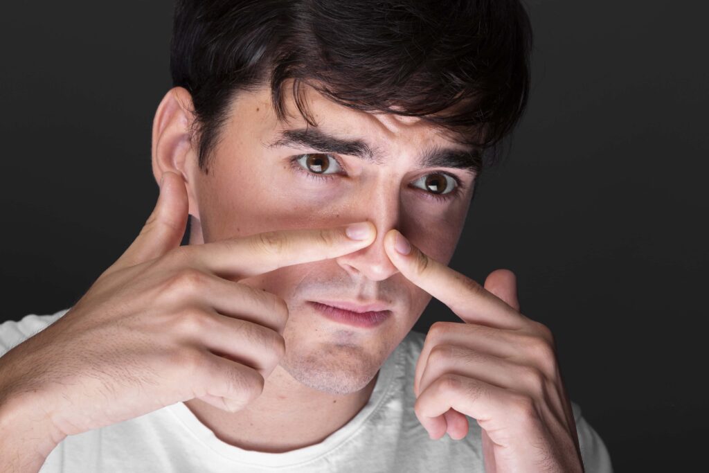 young man touching his droopy nose